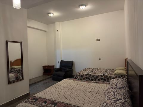 Habitación con dos camas y sillón