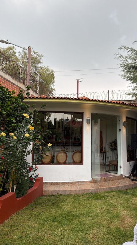 La oficina de Las Palomas, abierta al jardín, con rosales en la entrada